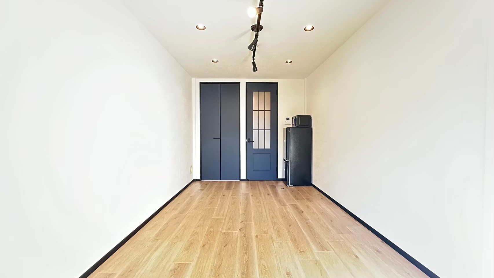 賃貸リフォーム施工事例｜ネイビー建具×木目床の洋室